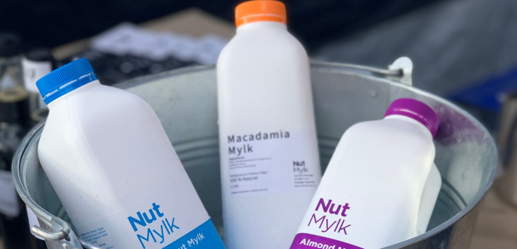 Almond, Coconut and Macadamia Mylk bottles in a silver bucket on ice