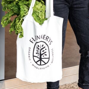 Photo of shopping bag filled with spinach with Flanneys logo printed on the front