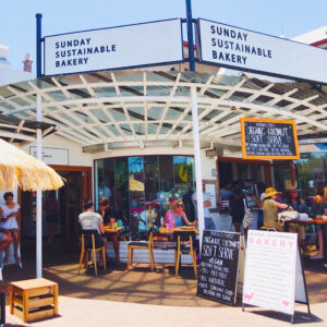 Front Image of Sunday Sustainable Bakery, Byron Bay with people sitting at tables out the front.